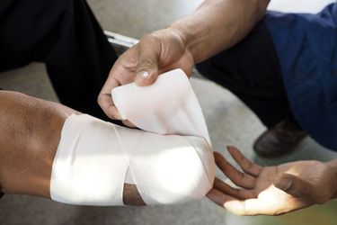 Medical professional wrapping amputated leg in gauze